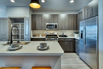 a kitchen with a large island and stainless steel appliances